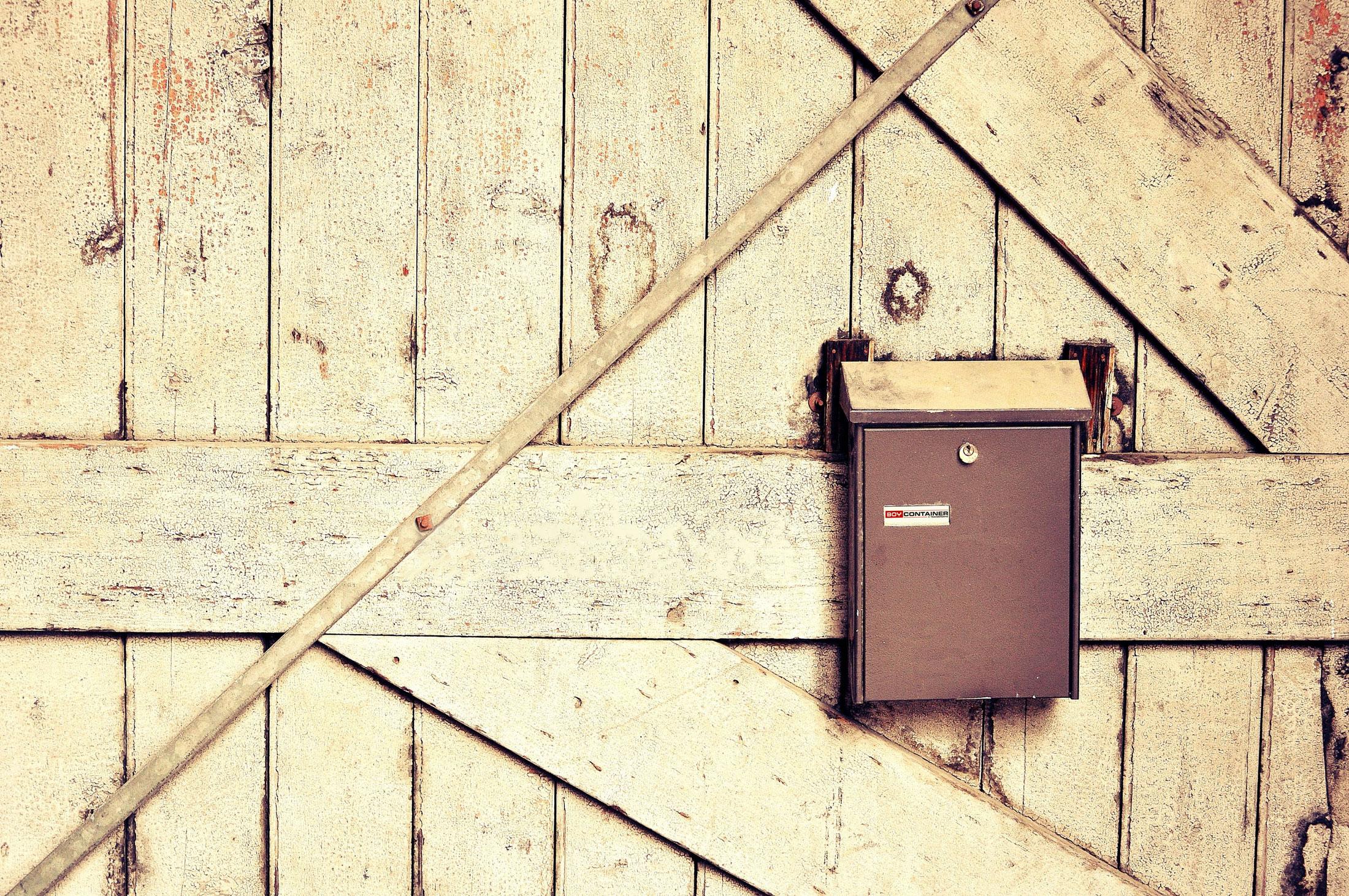 Briefkasten mit BOY Container Logo auf Holzhintergrund